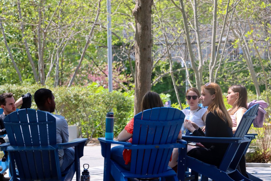 Nicholas School students sitting and talking in Adirondack chairs.